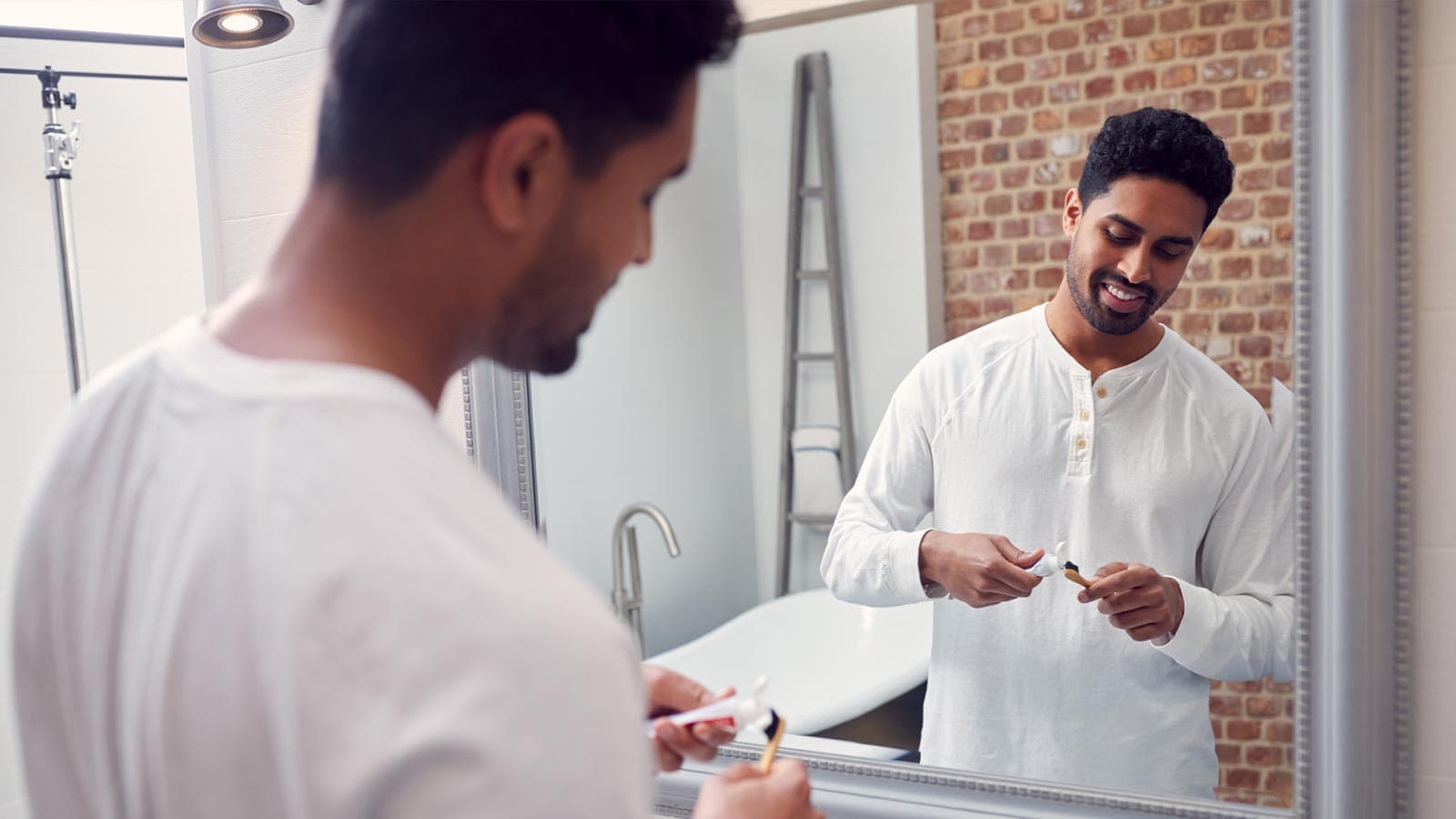 Man putting on toothpaste on toothbrush