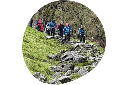 Denplan member dentists walking down a grass hill with rocks